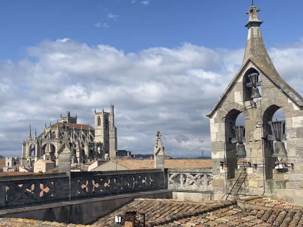 View of Catholic Cathedral from the rooftop of another church that has a bell tower in South of France