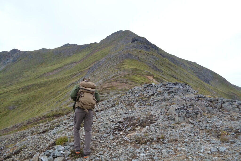Hiker climbing up rocky mountain