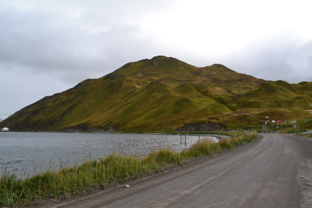 Road wrapping around the bay leading towards the mountain in Unalaska