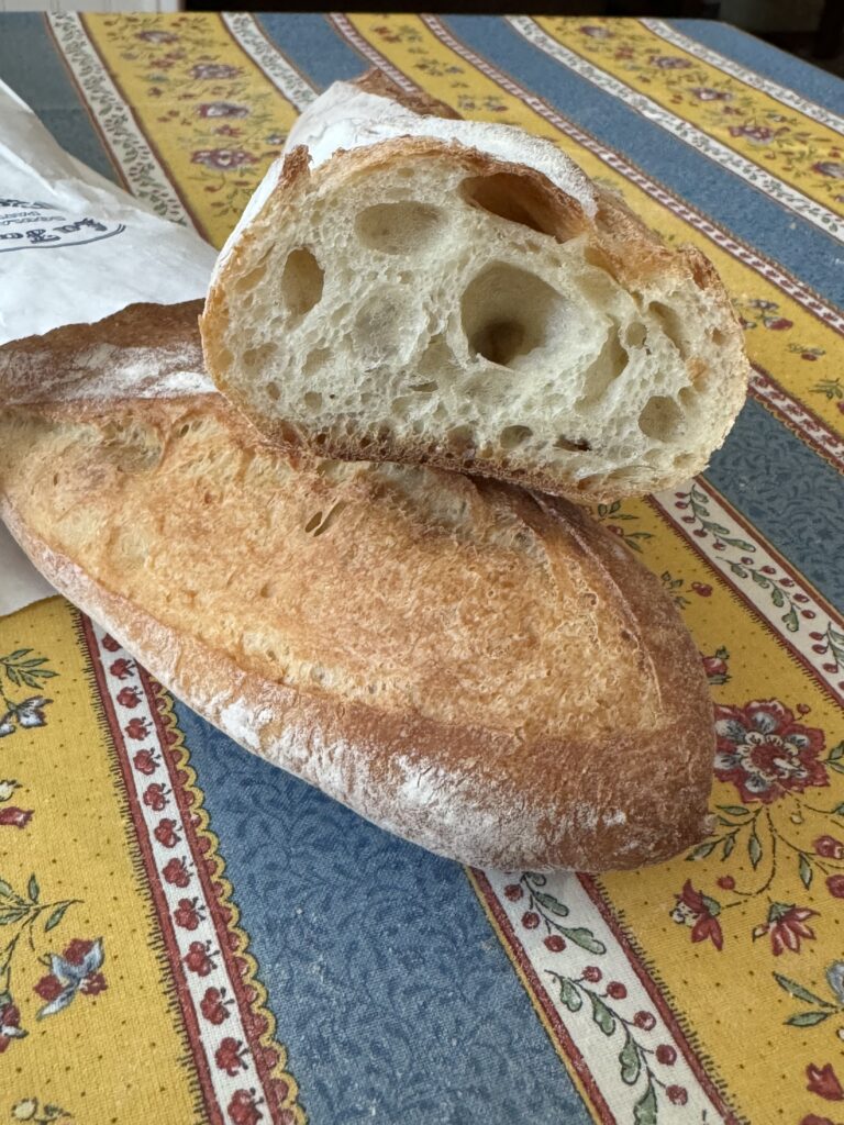 Baguettes with one cut in half to show the inside of a french baguette
