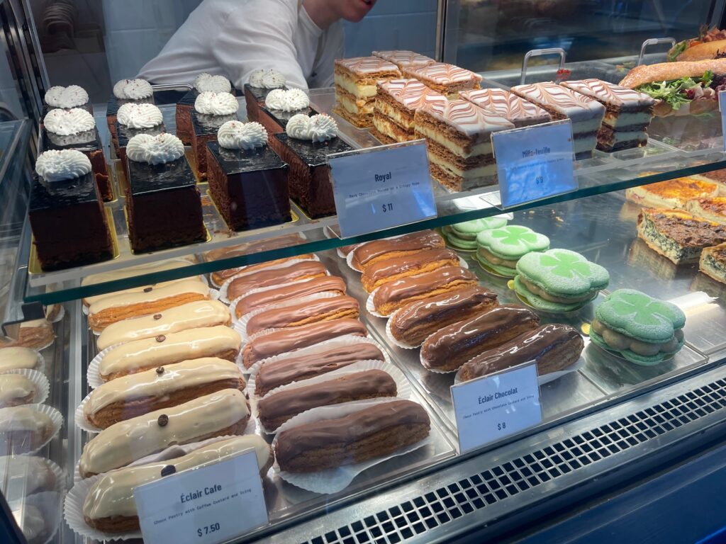 Glass case full of french pastries, eclairs, and cakes