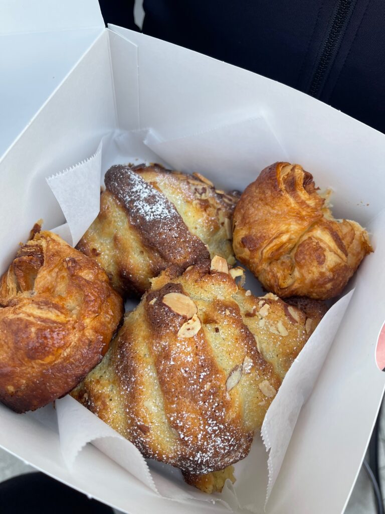 Pastry box filled with french almond croissants and kouign amanns