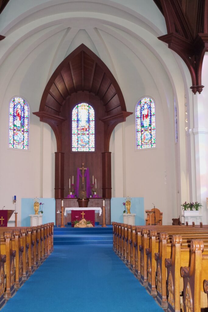 Swiss-inspired Catholic Church with wooden altar and accent highlighting the arched ceiling