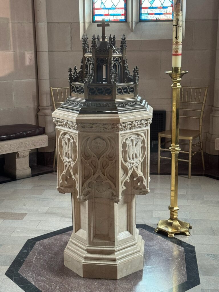 Gothic style marble baptismal font with Paschal candle
