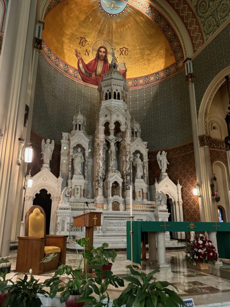 High altar at a Catholic Church with mosaic of Jesus in the domed ceiling that towers over the altar