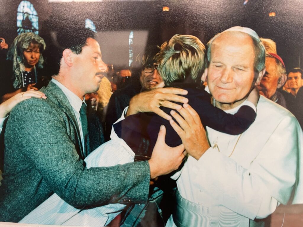 Pope John Paul II hugging boy held by his father in San Francsico