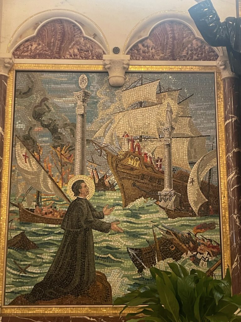 Mosaic of St. John Bosco in front of two ships in the sea