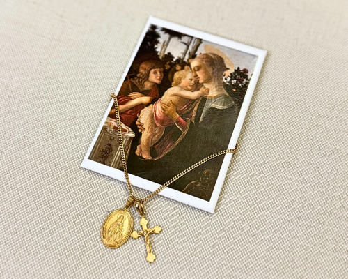Picture of a gold crucifix necklace on top of a picture of Virgin Mary holding Jesus