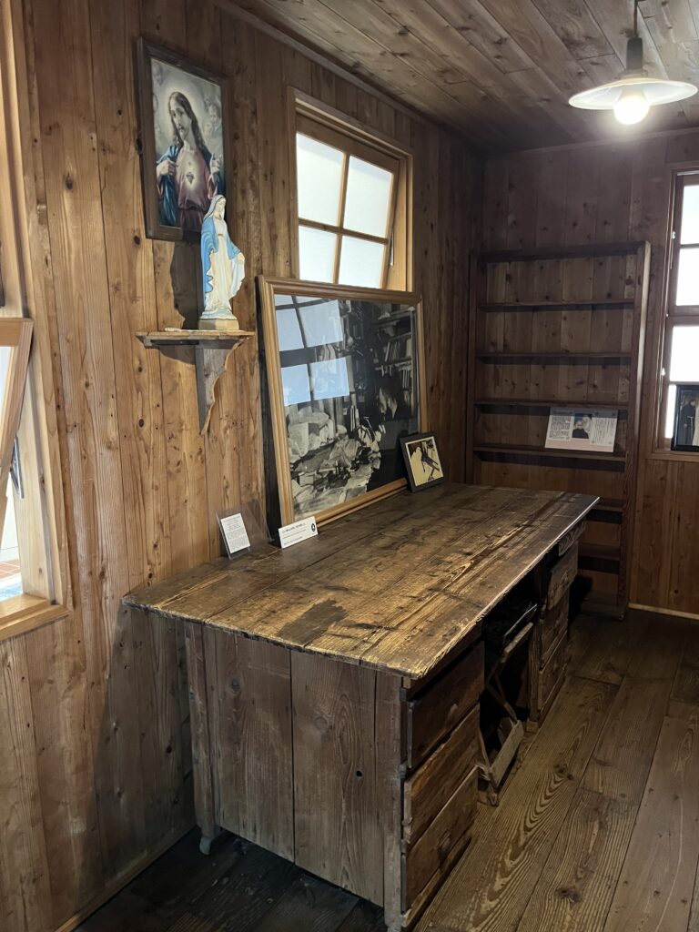 a wooden desk inside a wooden walled cell
