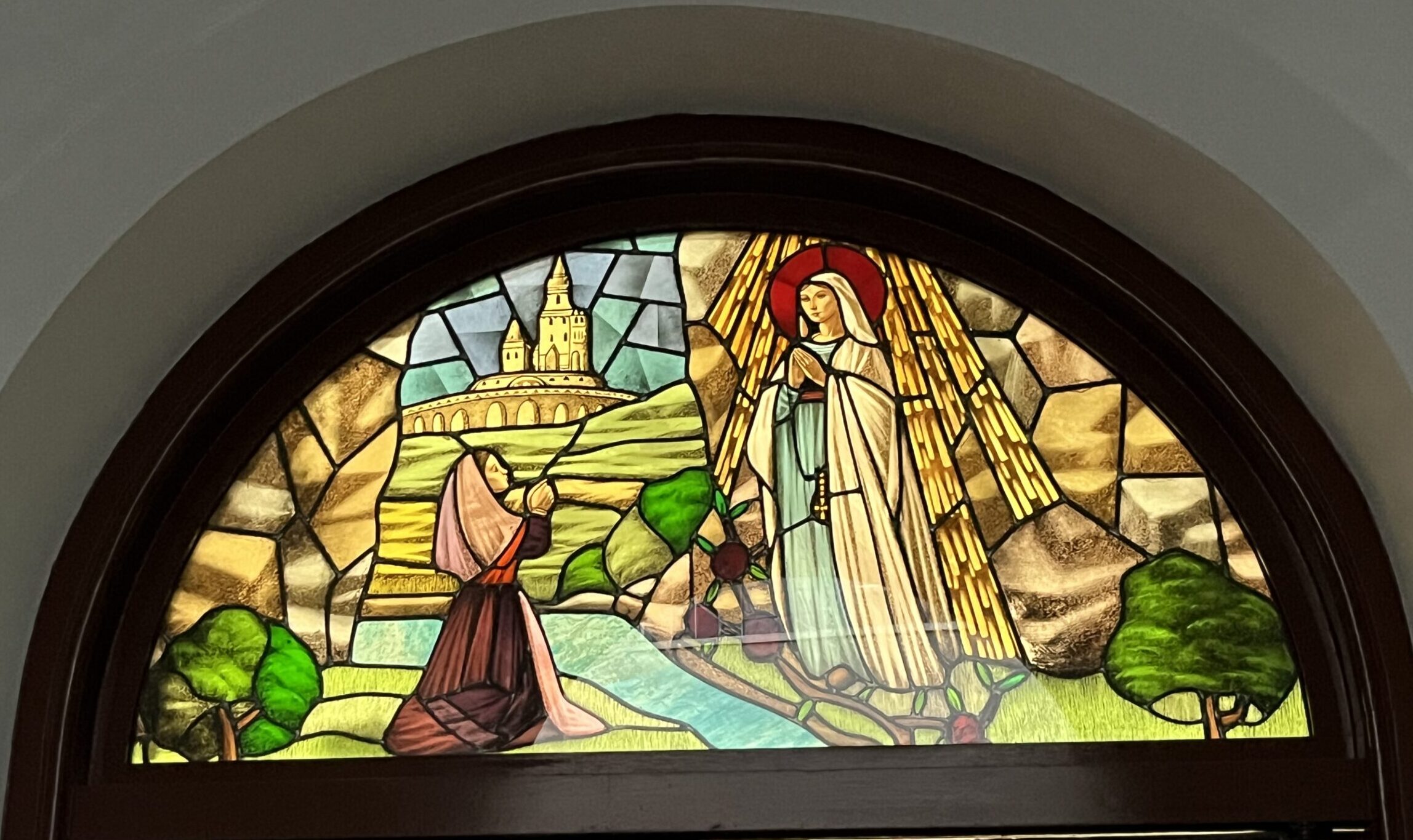 Stained glass representing the apparition of Mary to St Bernadette in Lourdes