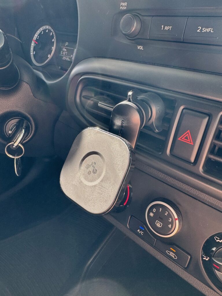 car mount attached to car air vent next to steering wheel