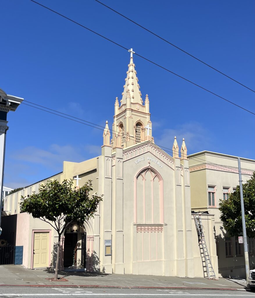 The outside wall of a catholic chapel with a steeple