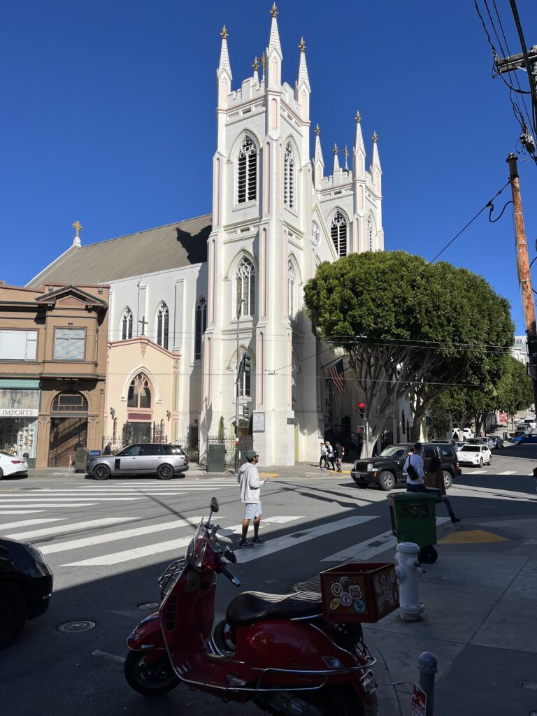 A scooter in the foreground of a cross section with a church across
