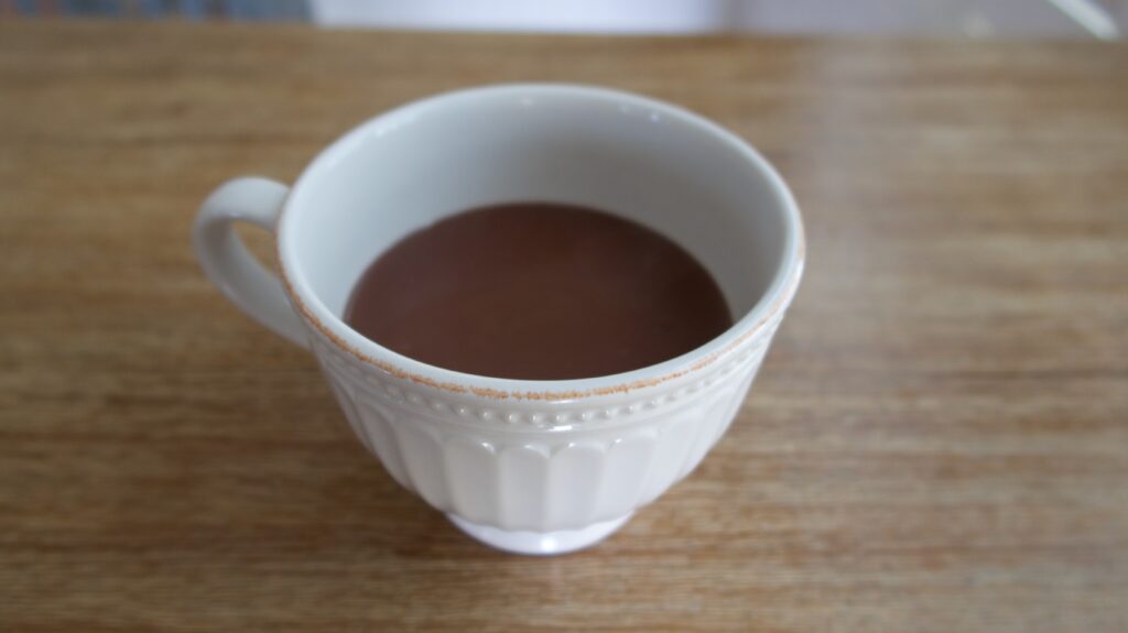 an ivory mug with thick french hot chocolate inside on a table
