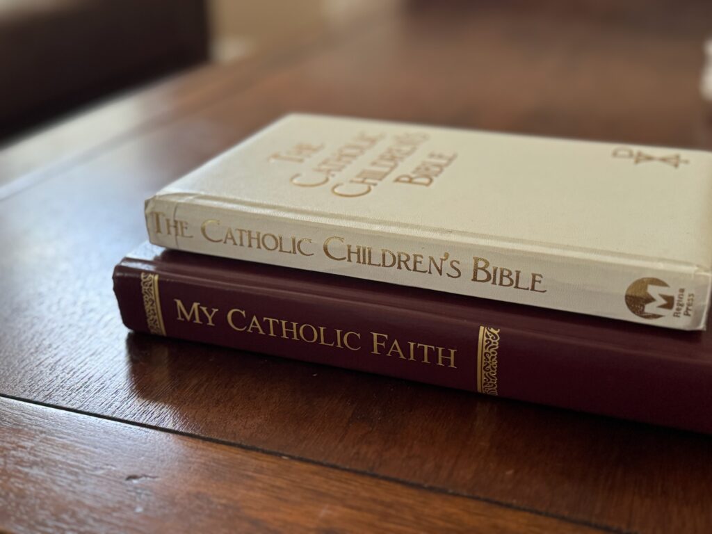 Two Catholic books on a wooden table