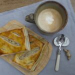 Puff Pastries, coffee, and utensils on a linen napkin on a wooden table