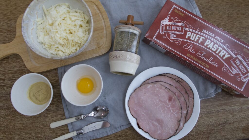 Ingredients to make a puff pastry dish laid out on a table with a blue napkin under it