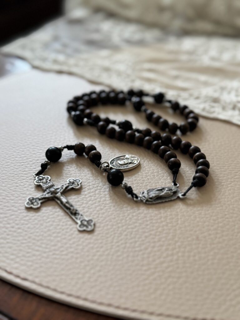 Rosary displayed next to a lace fabric