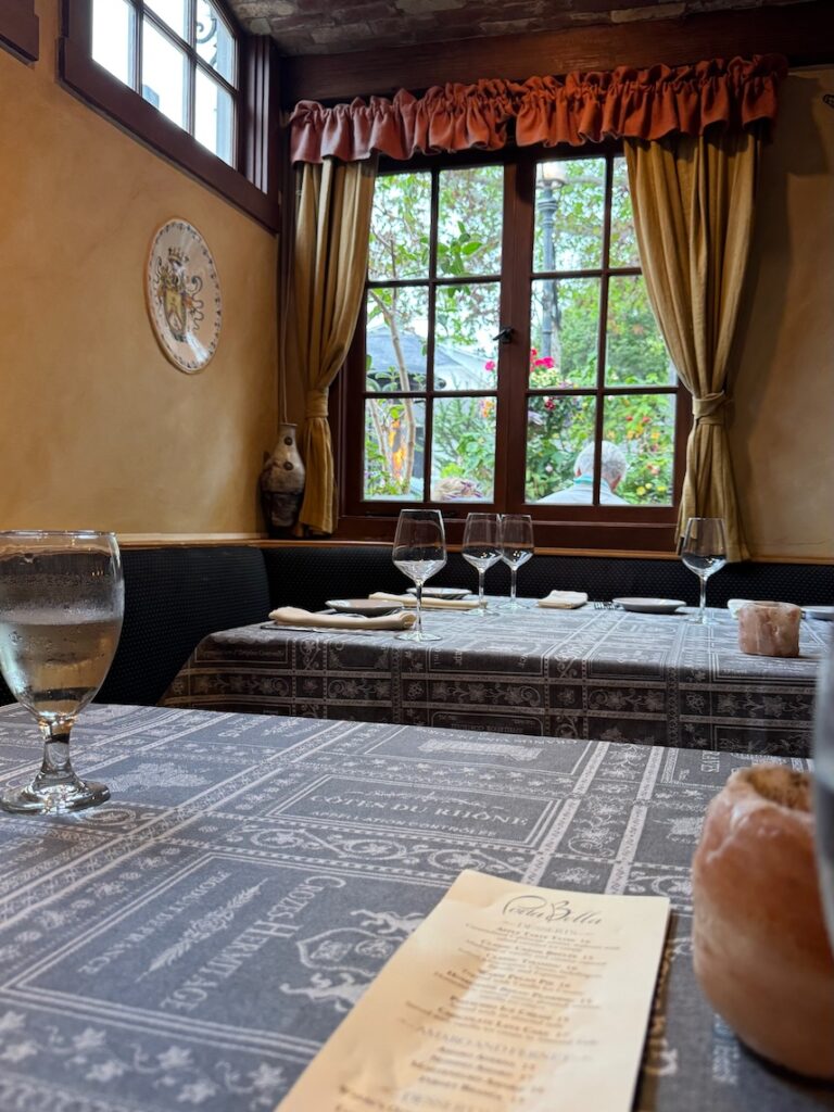 Interior of a restaurant in a vintage Italian restaurant style with a view of the window and tabletops