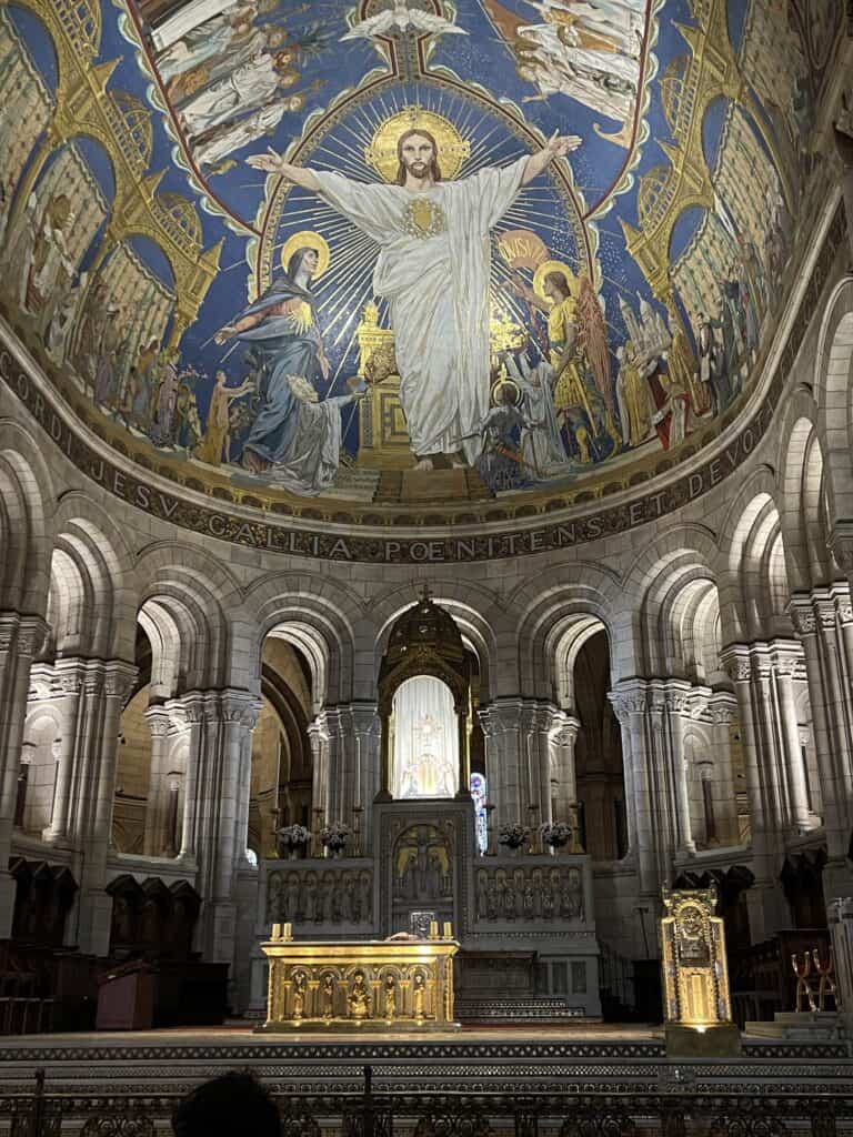 Interior of Sacré Coeur Basilica in Paris, Frace with large mosaic art on the vaulted ceilings and in the center a monstrance with the Holy Eucharist present for adoration