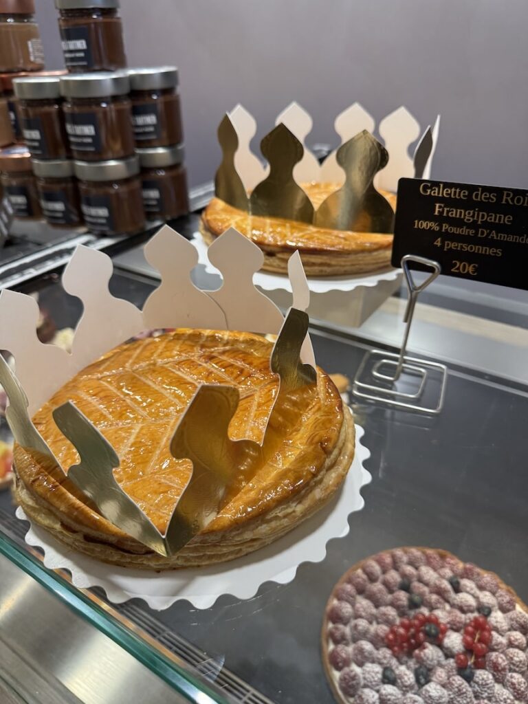 Two French puff pastry cakes (galette de rois) with golden paper crowns on it