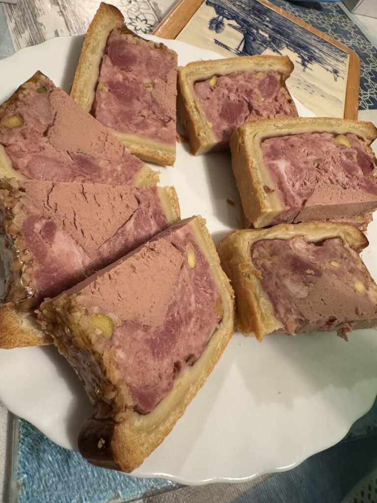 Plate with slices of pate en croute assembled neatly in a circle on it