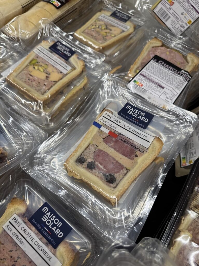 Neat piles of pate en croute individually shrink wrapped for sale