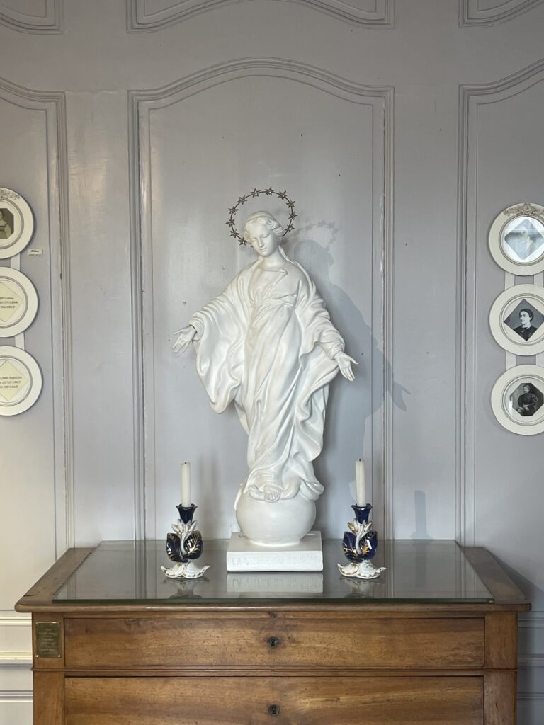 Statue of Our Lady of the Smile on a wooden dresser in the childhood room of St. Therese