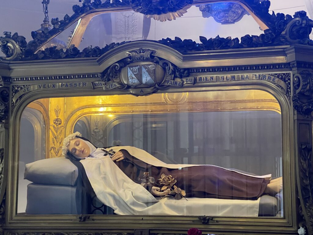 Tomb of St. Therese of Lisieux with glass casing and statue of her inside
