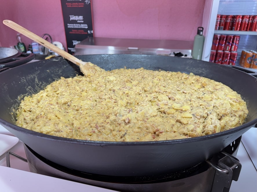 Huge shallow cauldron of tartiflette or a potato and cheese casserole