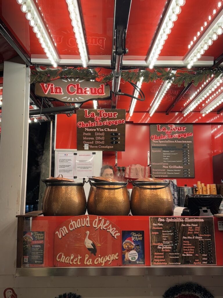 Decorated food stall at French Christmas marker selling various snacks such as hot wine and hot chocolate.
