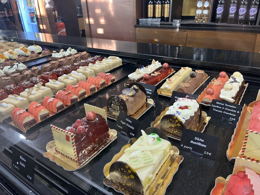 Yule longs of all shapes, sizes, and colors in a display case at a French bakery