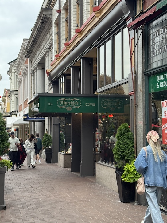 The exterior of Murchie’s Tea and Coffee store in Victoria, featuring a charming storefront with large glass windows. The entrance is framed by dark wood trim and a classic sign bearing the Murchie’s logo.