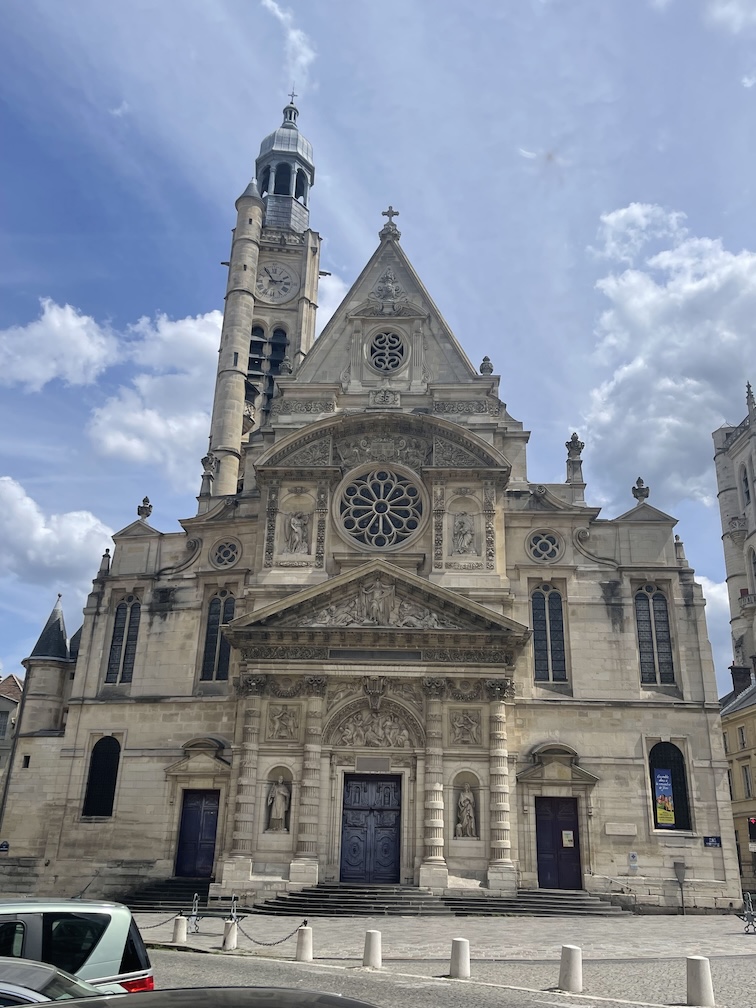 The stunning facade of Etienne Du Mont Churcho with a its bell and clock tower in the background