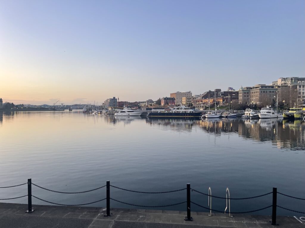 View of Victoria inner harbor looking out into the water towards moored boats and office and retails buildings behind it