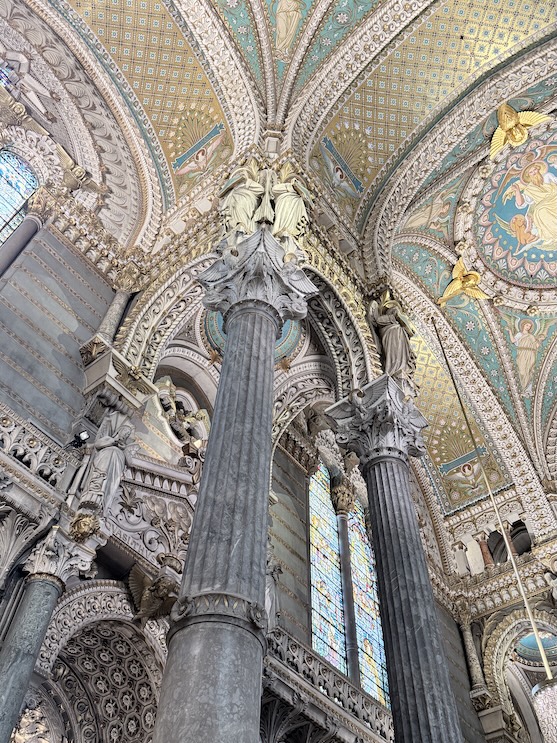 Decorated columns and mosaic ceiling inside the Basilica of Notre-Dame de Fourvière in Lyon, France.