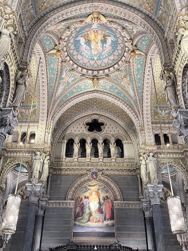 Interior arch and religious painting inside the Basilica of Notre-Dame de Fourvière, a historic church in Lyon, France.