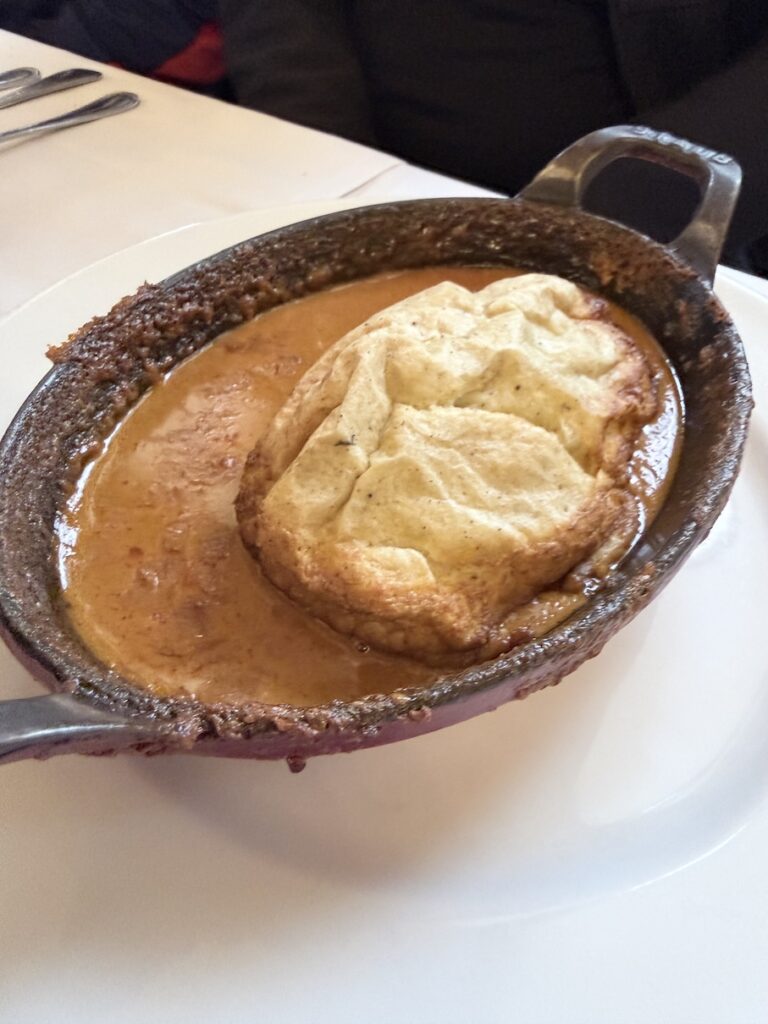 Traditional Lyon quenelle in rich sauce served at Brasserie Georges classic Lyonnaise cuisine restaurant