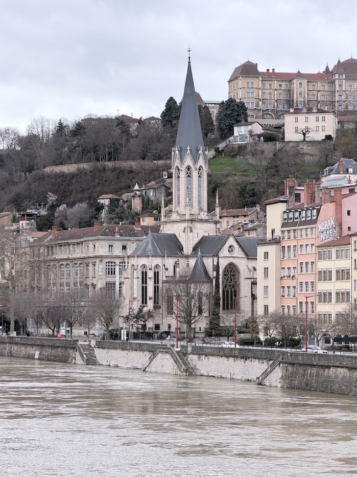Église Saint-Georges along the Saône River in Lyon’s Old Town, with hillside buildings in the background.