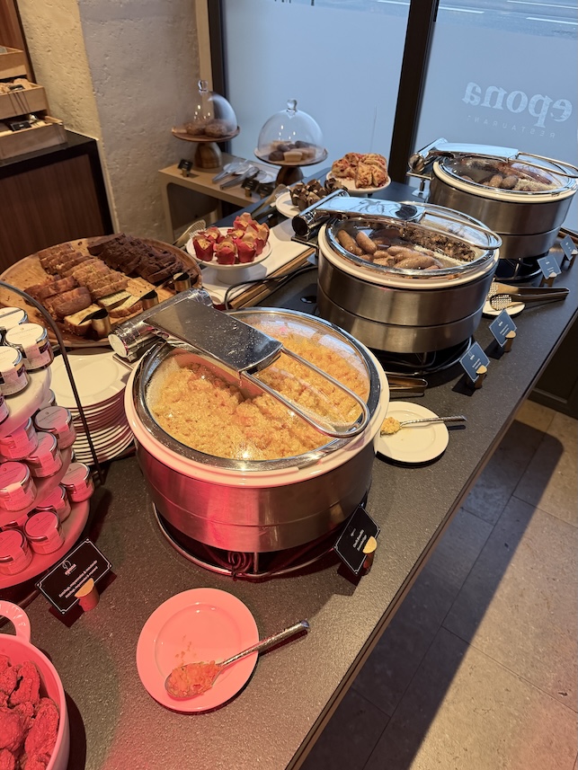 French hotel breakfast buffet in Lyon featuring pastries breads charcuterie and traditional morning foods