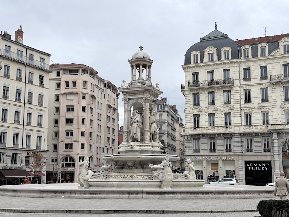 Place des Jacobins fountain surrounded by historic buildings in central Lyon, France.