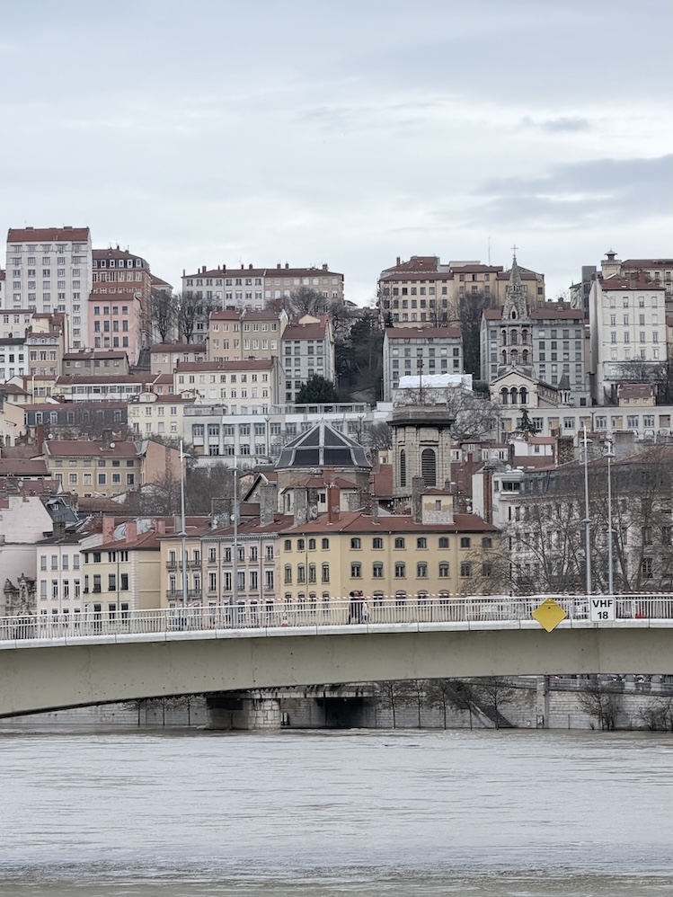 Lyon skyline with historic buildings and river bridge along the Saône River in Lyon, France.
