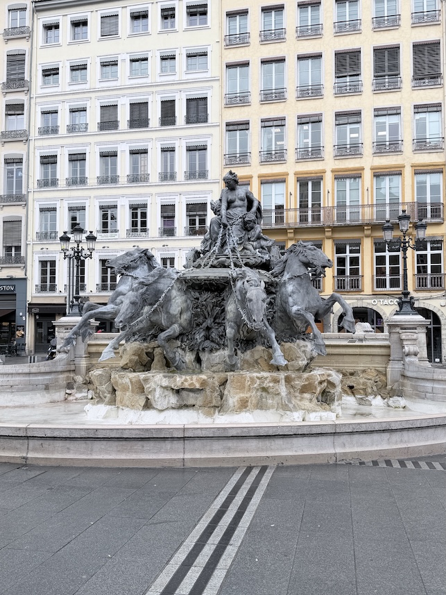 Bartholdi Fountain at Place des Terreaux surrounded by historic buildings in Lyon, France.