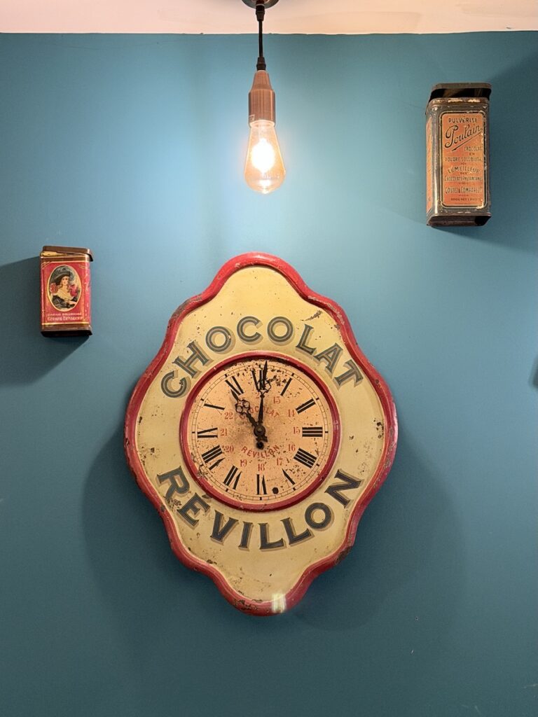 Vintage chocolat Revillon wall clock decor inside Ikône chocolate café Lyon France