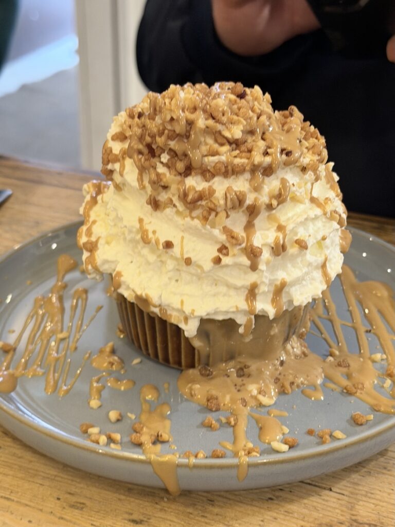 Giant praline dessert with whipped cream and caramel drizzle at Ikône chocolate café Lyon France